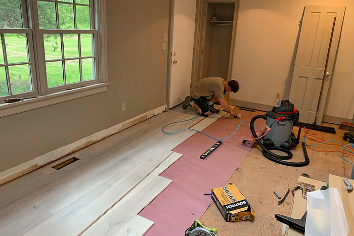 person installing hardwood floor